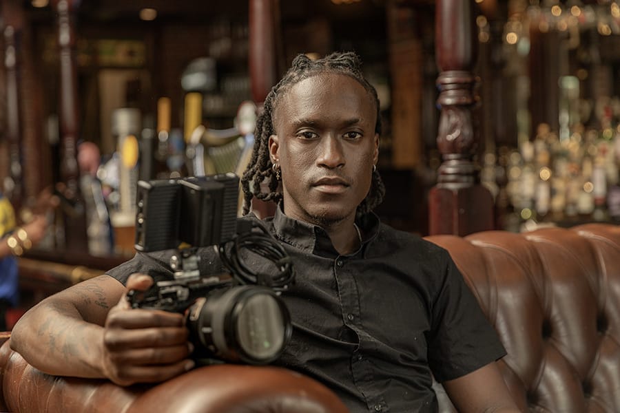 Christefor seated with his camera, photographed in a bar.